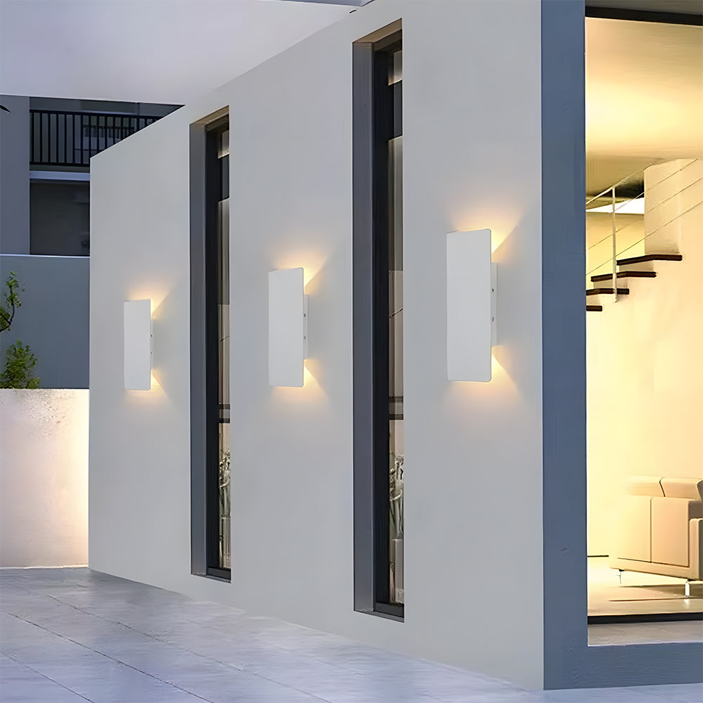 Row of white slim reta outdoor wall lights illuminating a modern exterior walkway