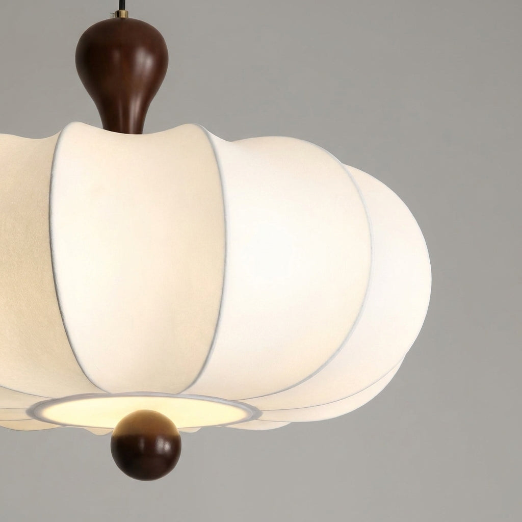 Rizqo sculpted fabric pendant light illuminated, angled view on a grey studio background