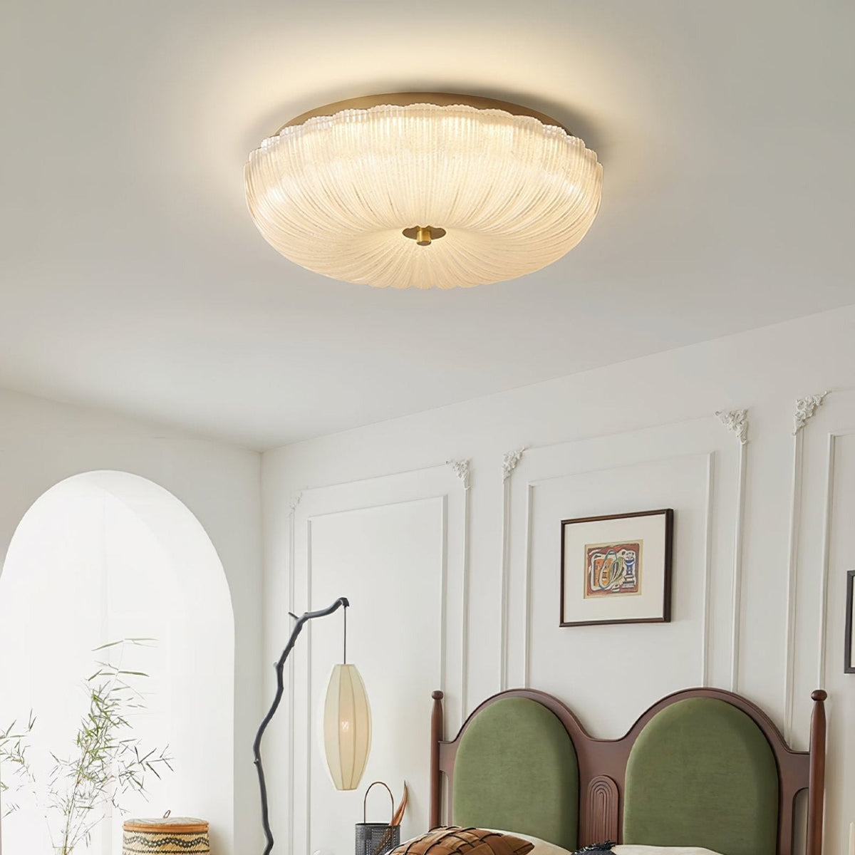 Ripple glass rutyl ceiling fixture providing soft ambient light above a green velvet bed