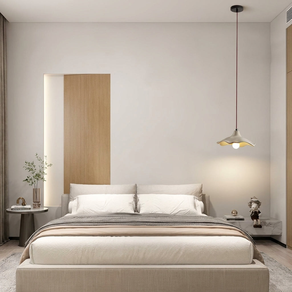Rylin scalloped concrete bell pendant light hanging beside a bed in a neutral minimalist bedroom