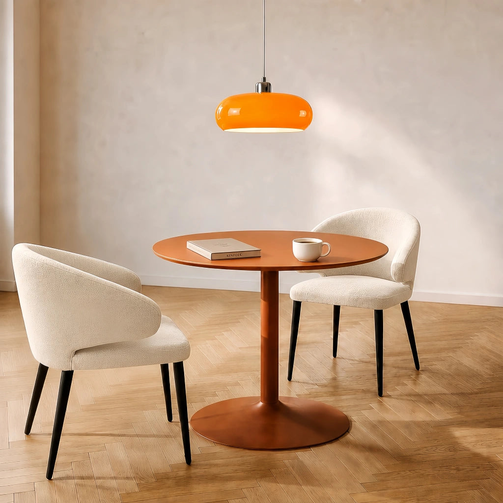 Orange glass dome seqa pendant light illuminating a cosy modern dining nook with a wooden table and two chairs