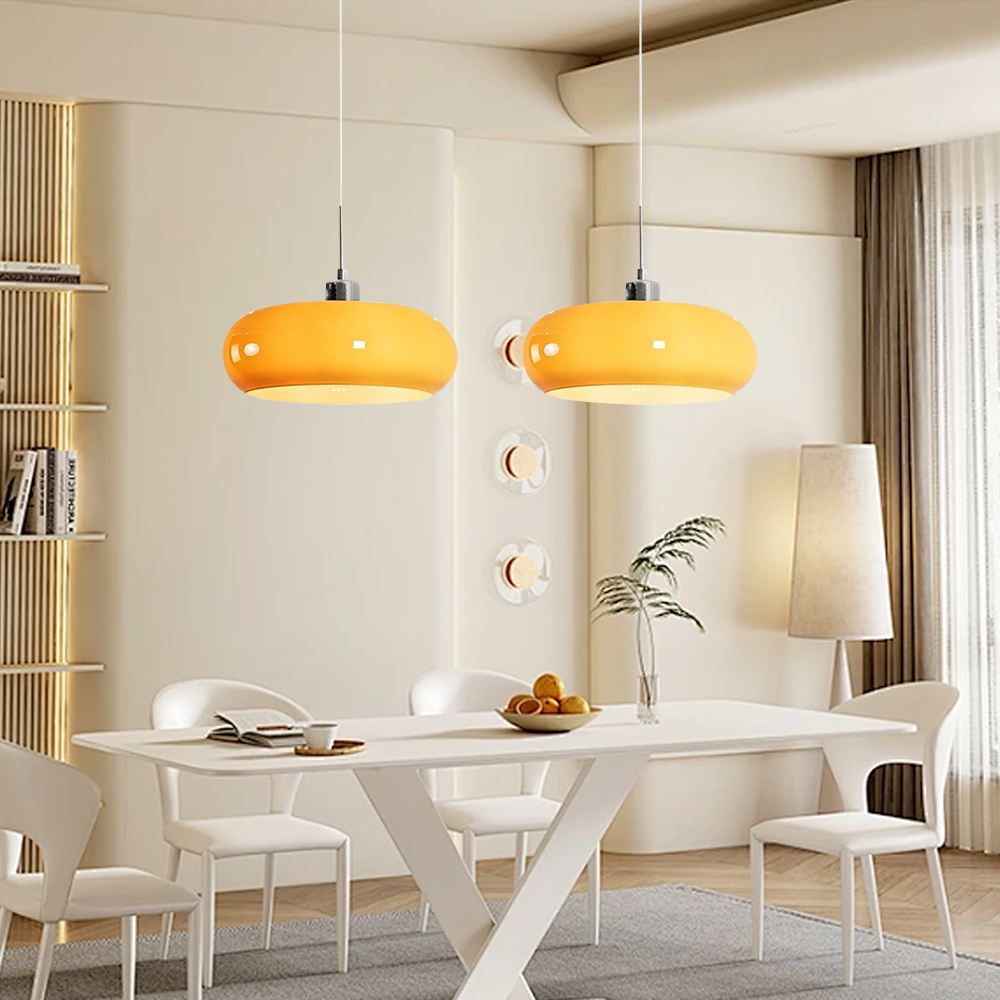 Pair of brown hand-blown seqa glass ceiling pendants lighting up a bright, contemporary white dining space