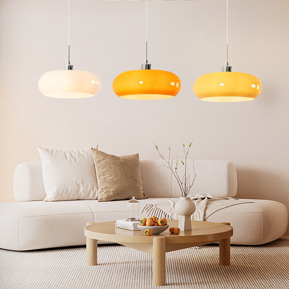 Three multicolour seqa glass dome pendants hanging in a stylish modern lounge area with a low cream sofa
