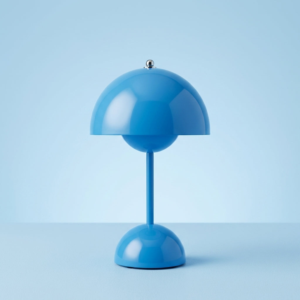 A modern sulba blue table lamp with a dome-shaped shade, a slender stem, and a matching round base, photographed against a soft light blue studio background.