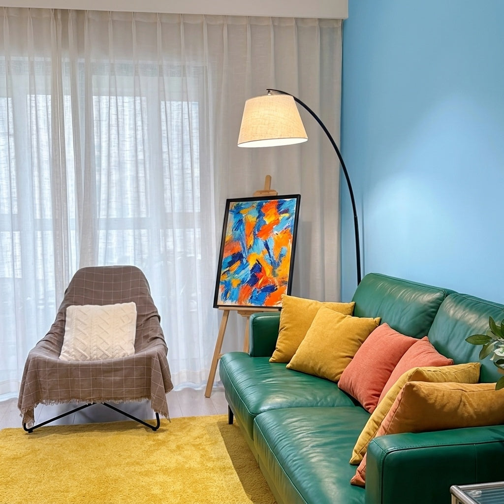 Tavio arc floor lamp reaching over an emerald green leather sofa in a bright blue living room