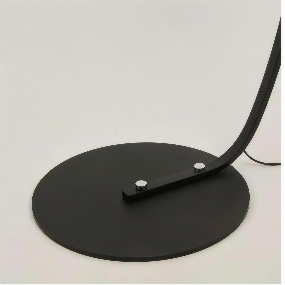 Close-up of the Tavio arc floor lamp round black metal base