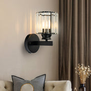 Modern teja black round crystal wall sconce providing warm ambient light above a sofa in a living room