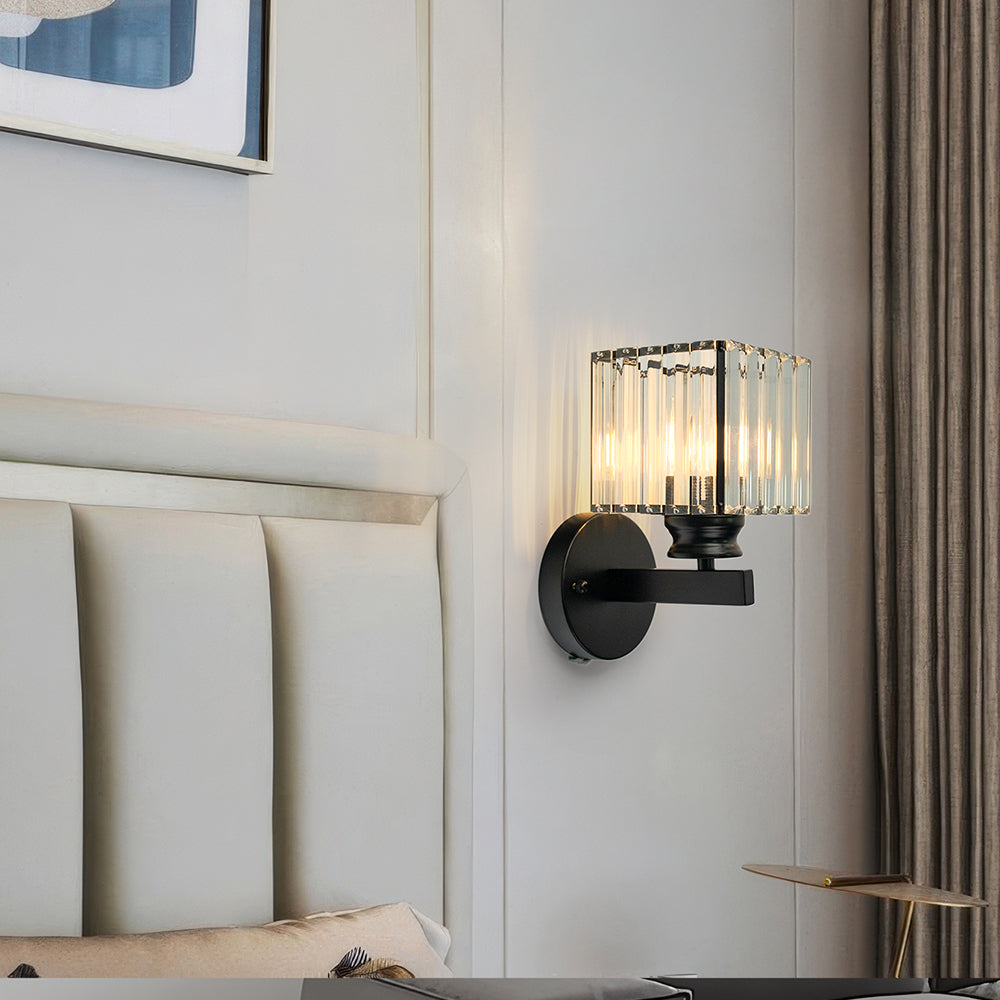 Illuminated teja black square crystal wall sconce showing beautiful light refractions on a white wall