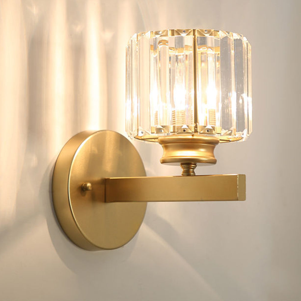 Gold teja round crystal wall sconce casting intricate starburst light patterns on a light wall