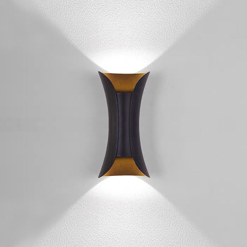 Modern black and gold teka hourglass LED outdoor wall light casting a sharp V-shaped beam