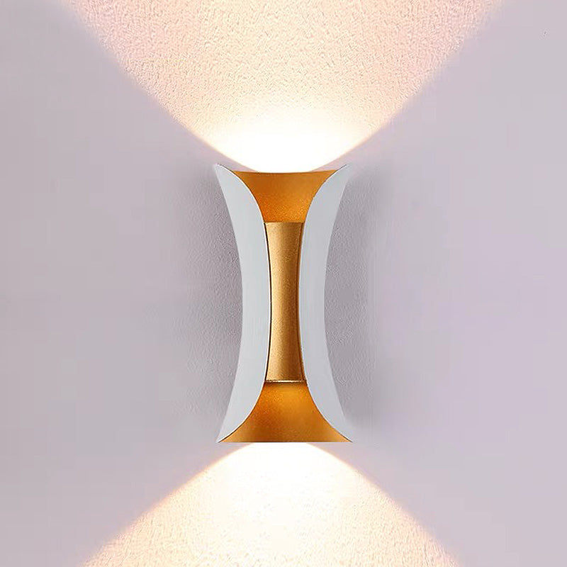 teka modern white and gold exterior wall sconce casting a bright, symmetrical light beam