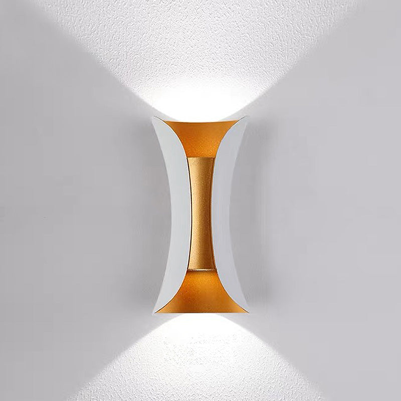 Elegant teka white and gold hourglass outdoor wall lamp creating a distinct light and shadow pattern