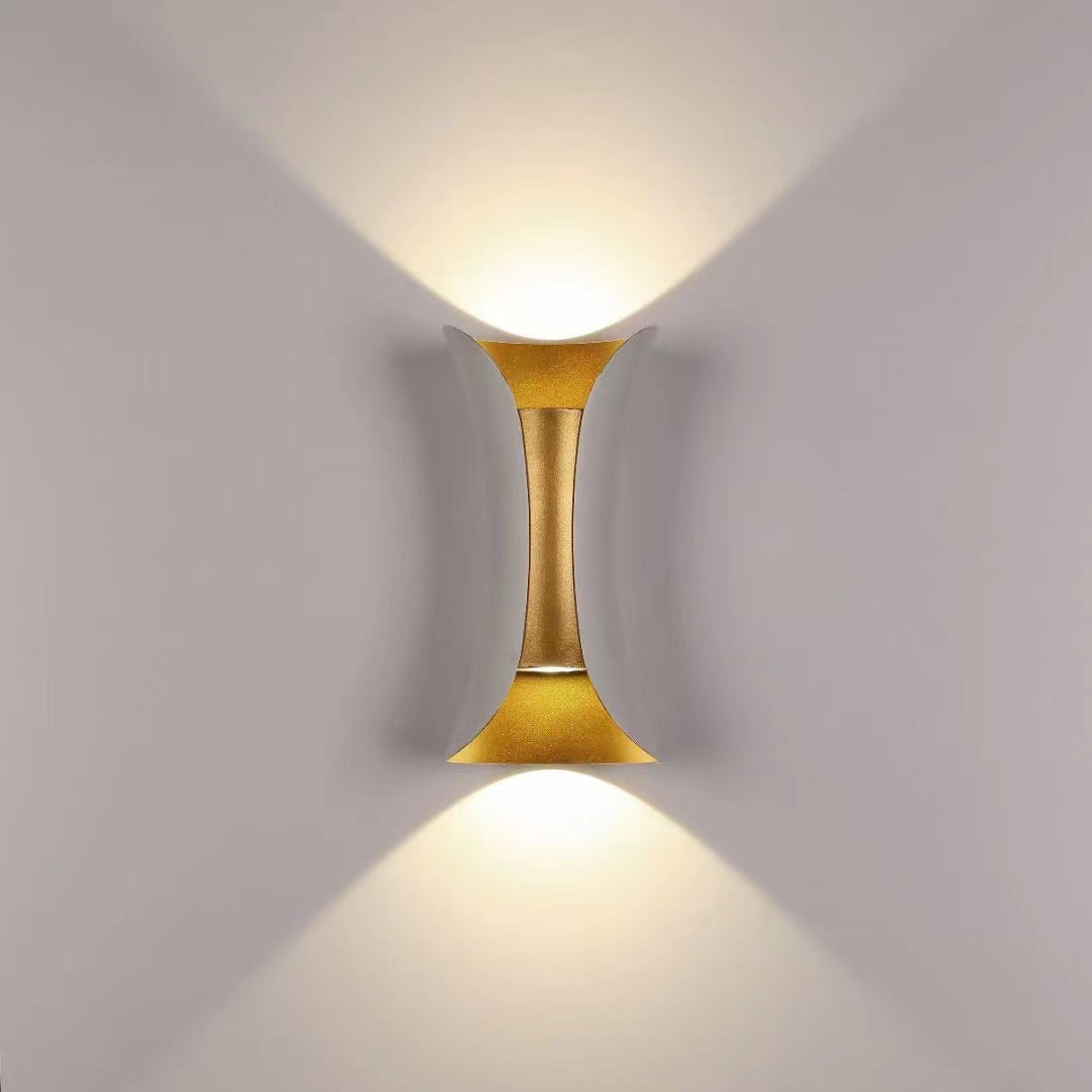 Illuminated teka white and gold LED up and down sconce against a neutral, warm background
