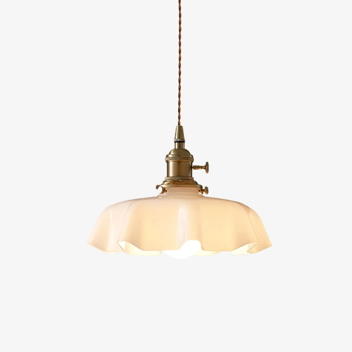 Isolated view of the vintage scalloped cream glass tugyl pendant highlighting its braided cord and antique brass fitting