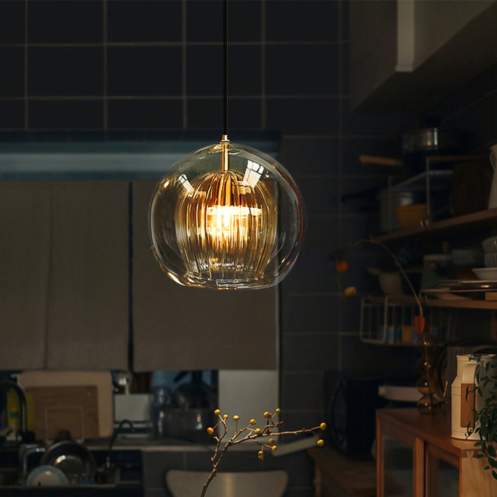 Warm amber tuoj glass globe pendant light adding a cosy ambience to a dark, modern kitchen setting