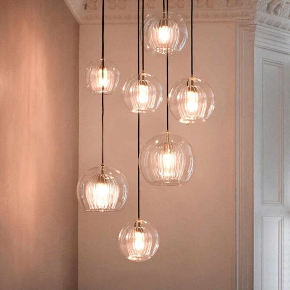 Stunning cascading cluster of clear and amber double-layer tuoj glass pendants in a modern hallway