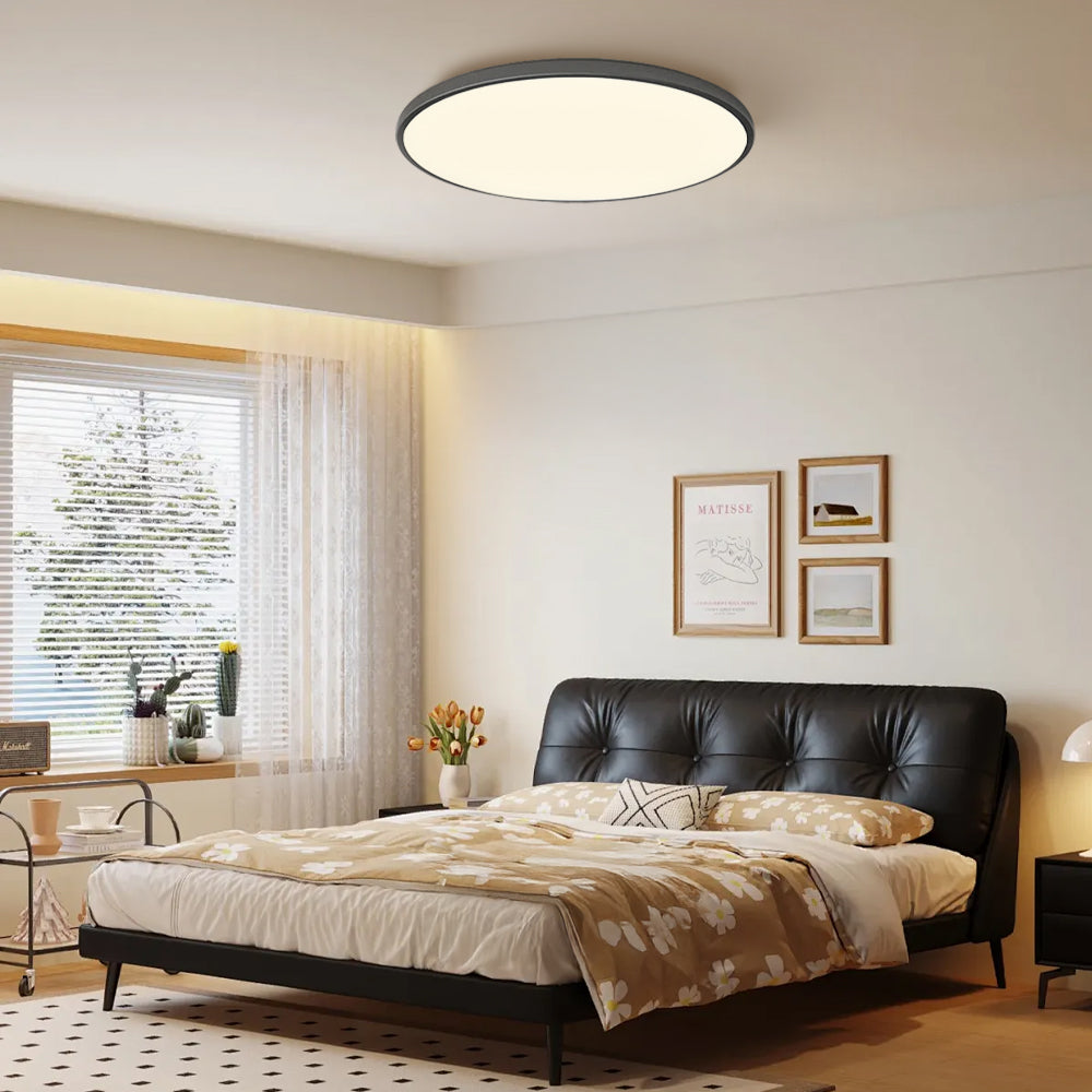 black round flush mount tywa ceiling light in a naturally lit modern bedroom.