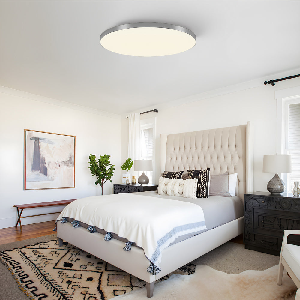 Silver minimalist LED flush mount tywa ceiling light in a stylish bedroom with a patterned rug
