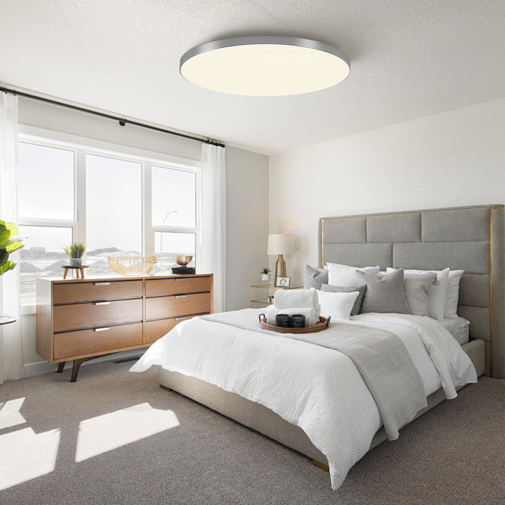 silver round LED flush mount tywa ceiling light in a bright, airy contemporary bedroom