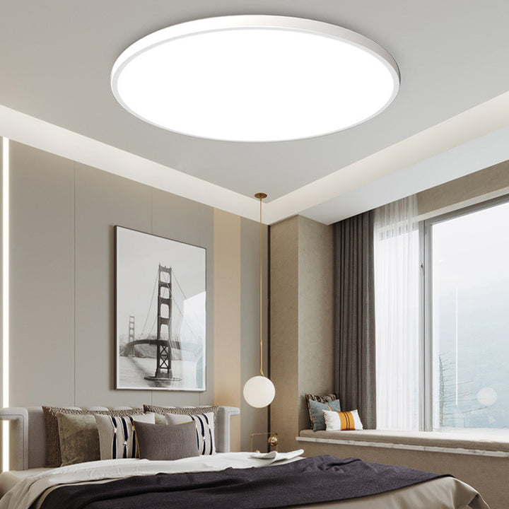 Modern white round LED flush mount tywa ceiling light illuminating a contemporary bedroom space