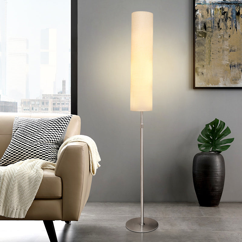 Contemporary white fabric vatel floor lamp styled next to a beige sofa in a bright, modern interior