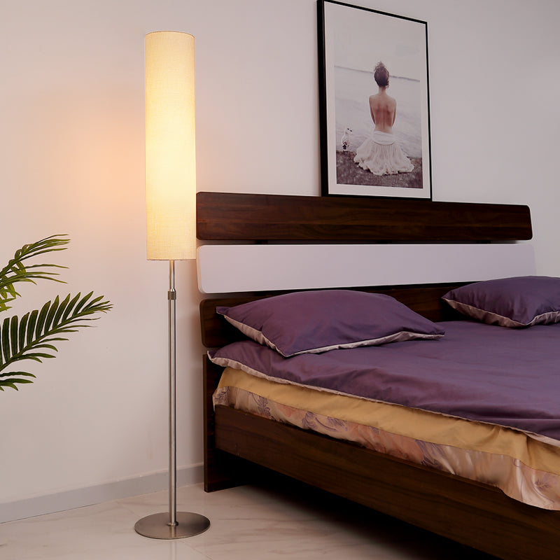 Modern cylindrical vatel floor lamp providing relaxing ambient lighting in a contemporary bedroom