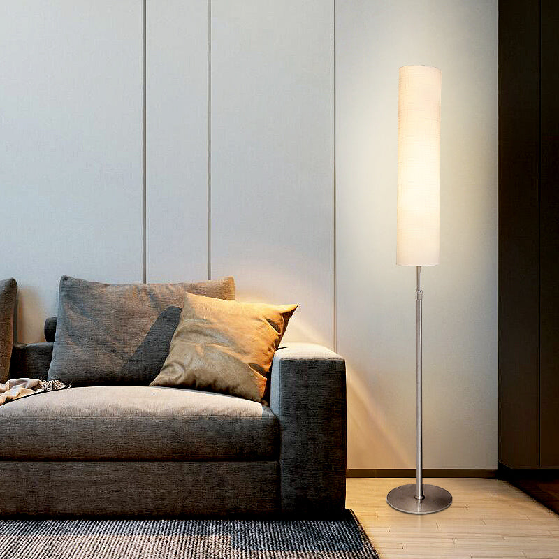 Sleek metal base vatel floor lamp with a tall fabric shade in a minimalist living room lounge