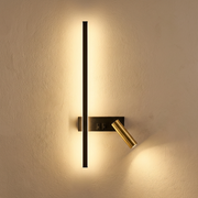 Modern veqi linear LED wall sconce in black and gold with an adjustable reading spotlight glowing warmly