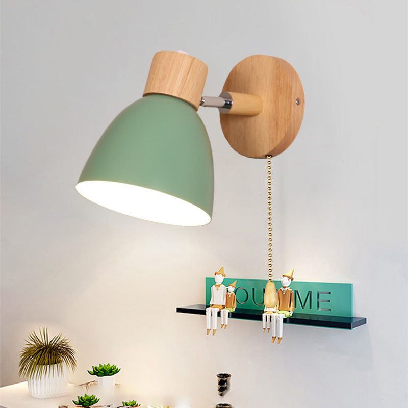 Green wood vexol wall sconce with a pull chain mounted above a decorative shelf