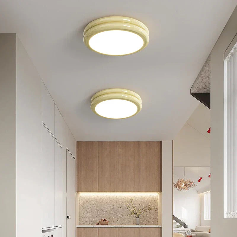 Pair of milky yellow macaron vyter ceiling lights illuminating a bright, modern kitchen space