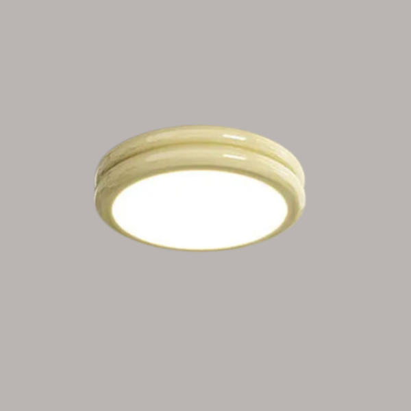 Milky yellow round LED flush mount vyter fixture isolated against a neutral background
