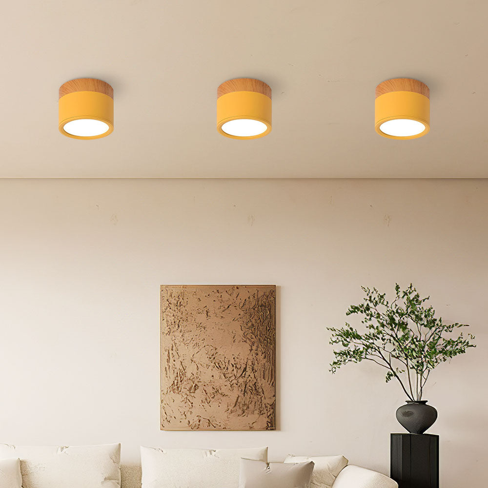 Three vibrant yellow cylinder surface vytri spotlights illuminating a minimalist living room