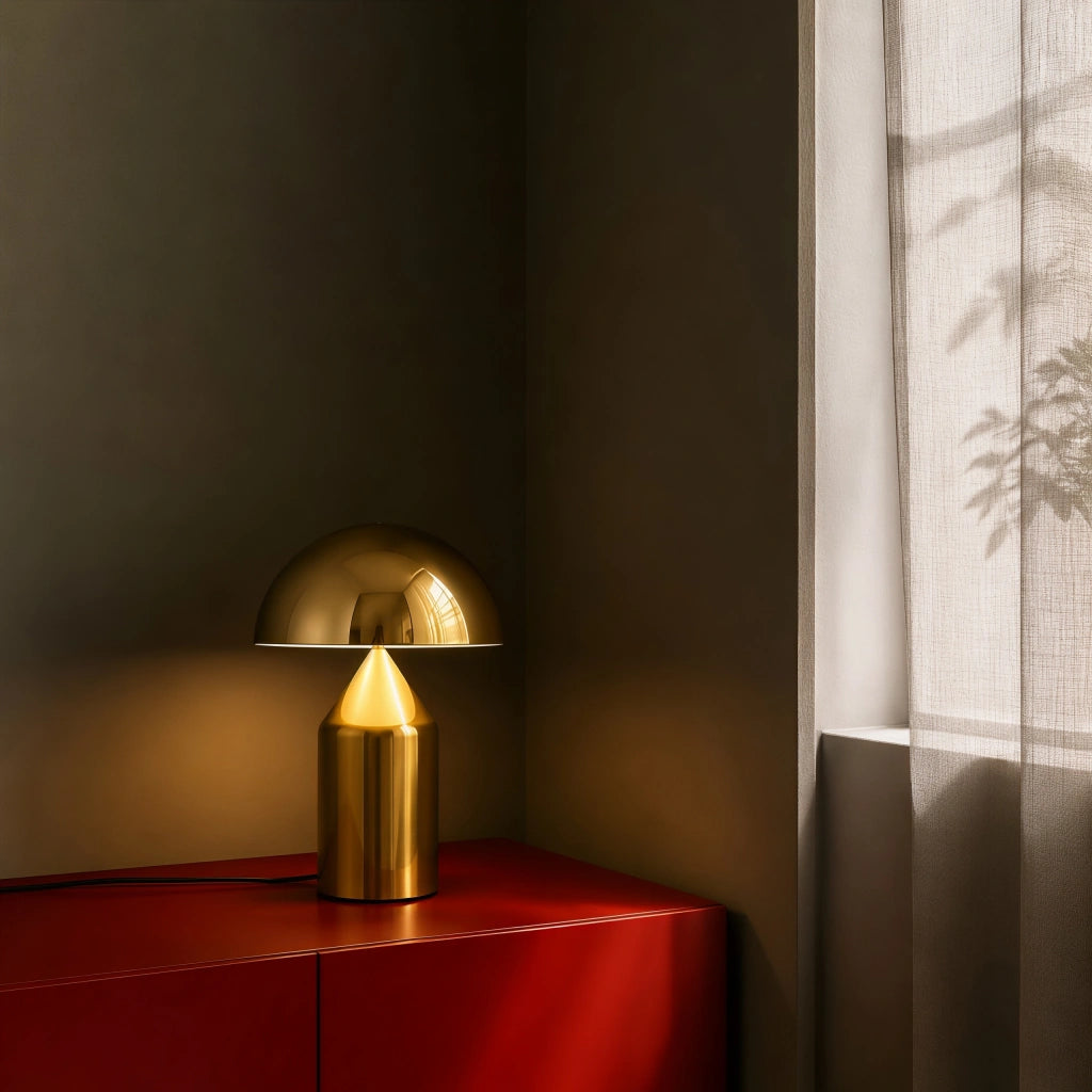 Gold retro dome wesk table lamp casting a warm, highly focused light on a dark red cabinet