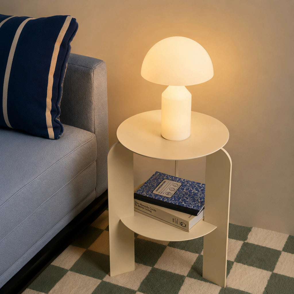 Space Age white wesk mushroom table lamp acting as a minimalist bedside reading light next to a blue sofa