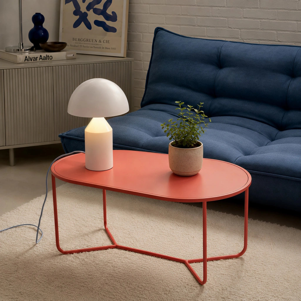 White mid-century wesk mushroom desk light styled on a modern red coffee table in a living room