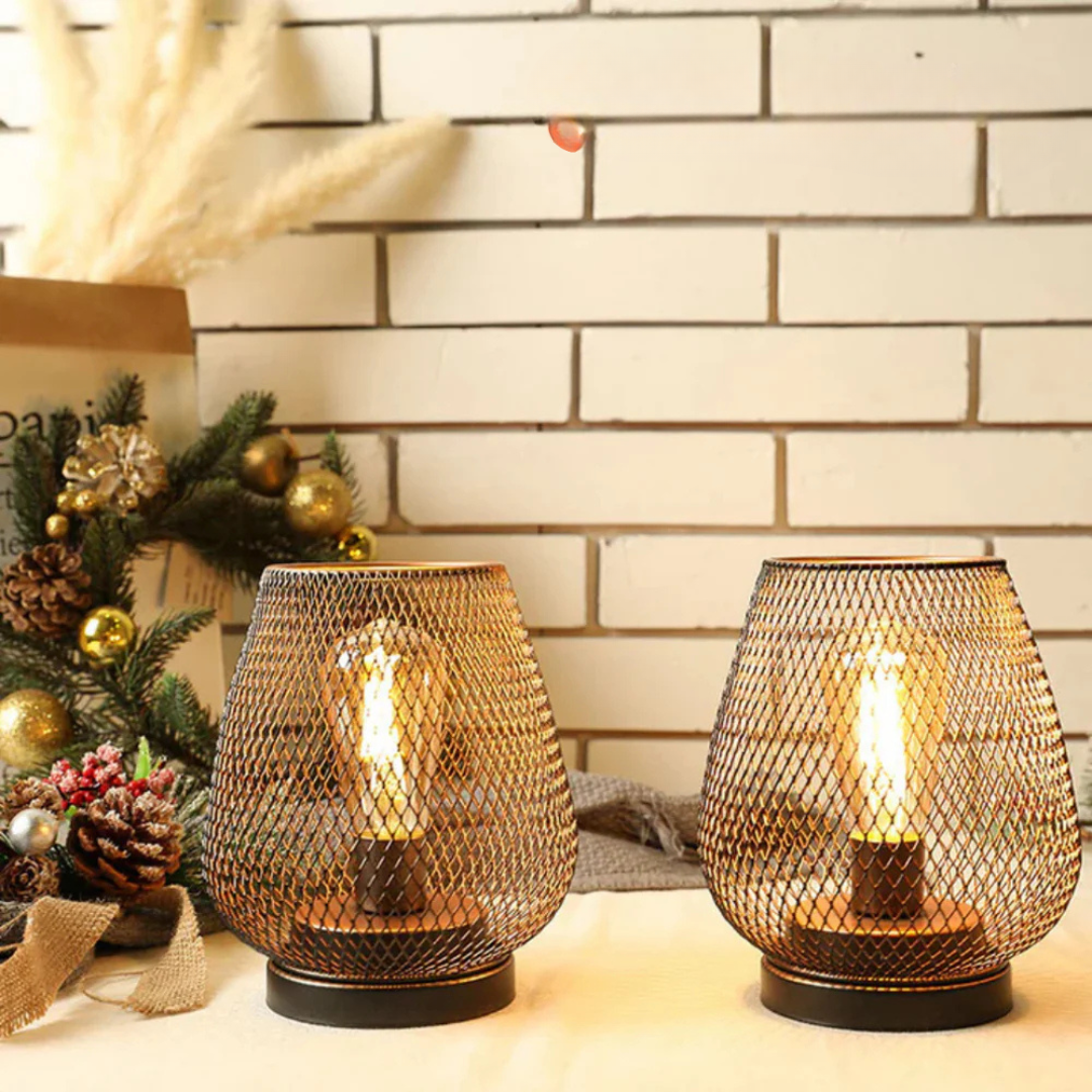 Portable xolu metal cage lanterns acting as elegant ambient lighting next to festive decor and a white brick wall