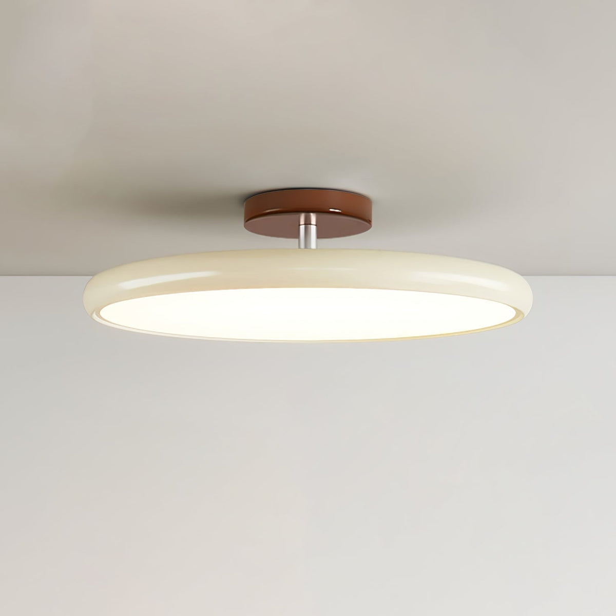 Beige tilting xome ceiling lamp installed on a white ceiling, angled downwards
