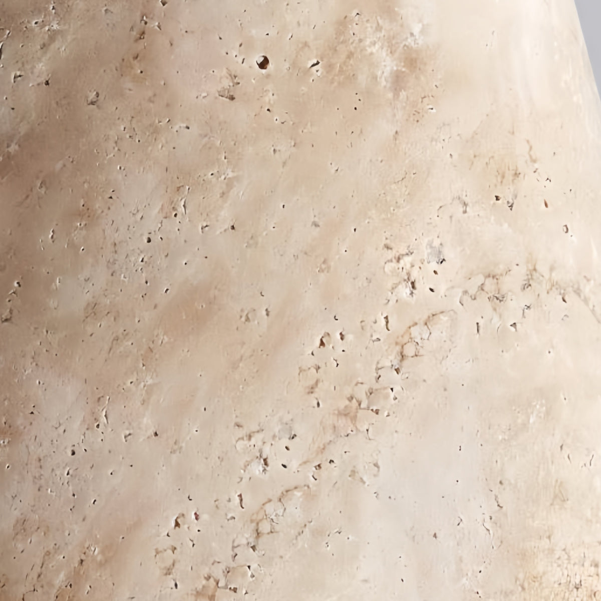 Close-up of the Yomzi pendant light's textured travertine stone surface