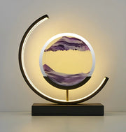 Modern LED moving sand art youj table lamp featuring a black circular frame and flowing purple sand