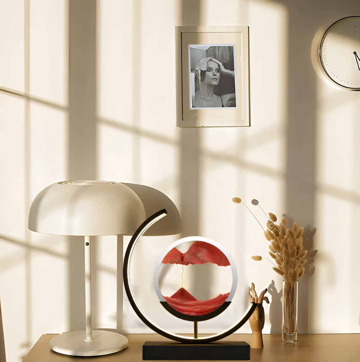 Modern sand art youj bedside lamp with a black frame and orange sand styled on a wooden desk
