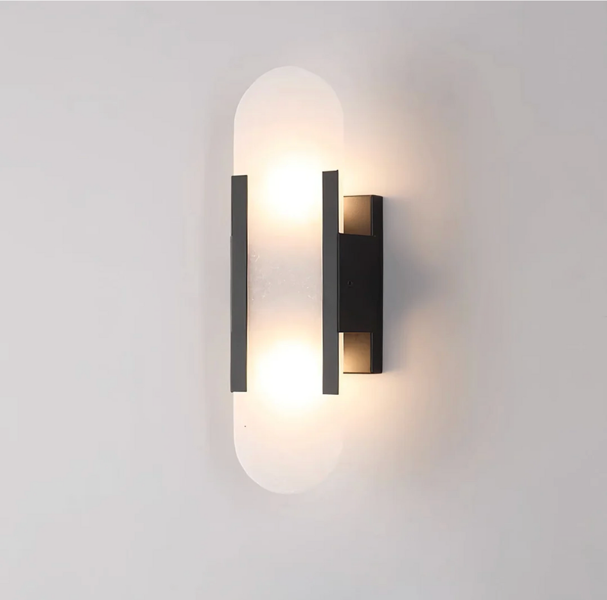 Angled view of the minimalist black marble yuhy capsule wall light