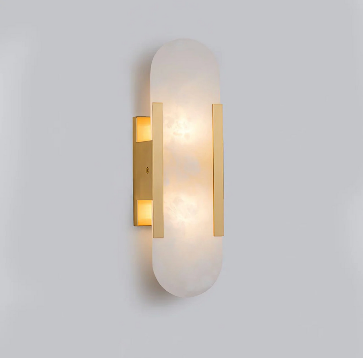 Modern yuhy gold dolomite marble pill-shaped wall sconce casting a warm, ambient glow