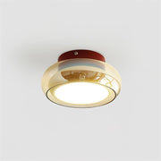 Modern retro flush mount zuba ceiling light featuring a red metal base and an amber tinted glass shade