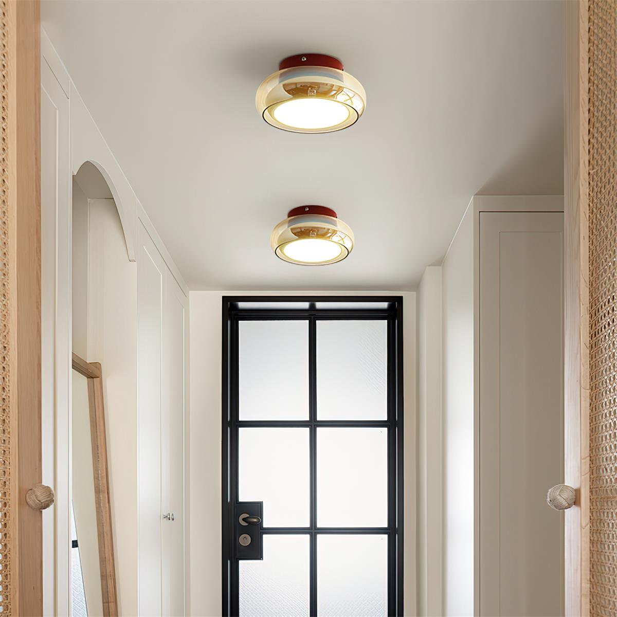 Pair of amber glass flush mount zuba ceiling lights illuminating a modern hallway corridor
